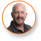 Smiling bearded man in dark shirt, expert in LED grow lights for cannabis.