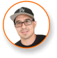Man in black cap and glasses, smiling, framed by orange circle; cannabis LED grow light expert.