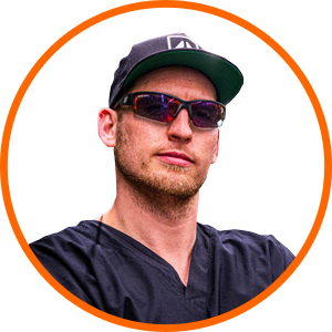 Man in cap and sunglasses with cannabis LED grow lights for commercial cultivation.