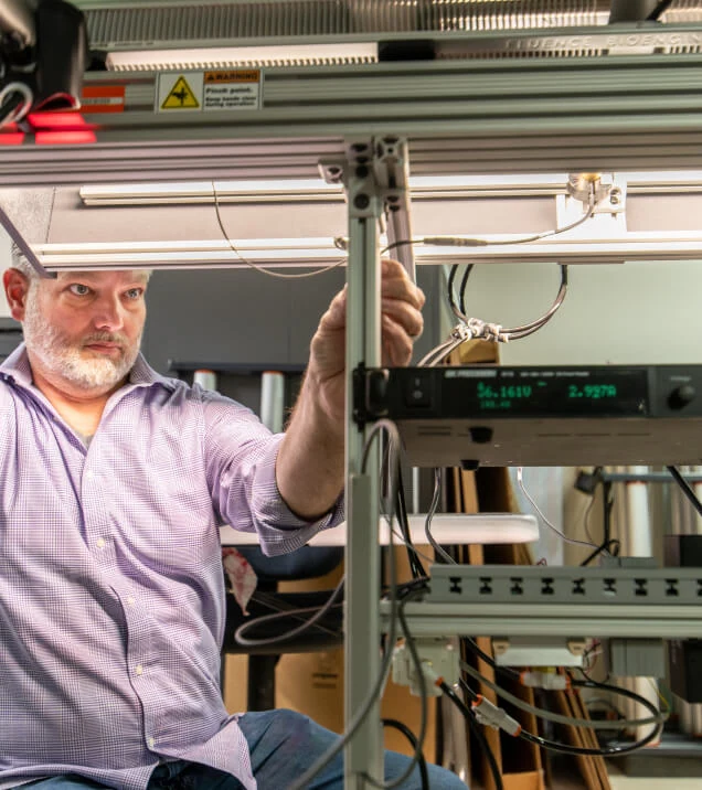A man in a lab tests LED grow lights for cannabis in a commercial cultivation facility.