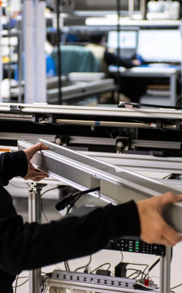Technician assembles LED grow lights for cannabis in a commercial cultivation lab.