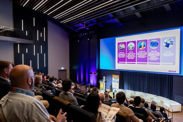 Audience in a modern auditorium attends a seminar on LED grow lights for cannabis cultivation.