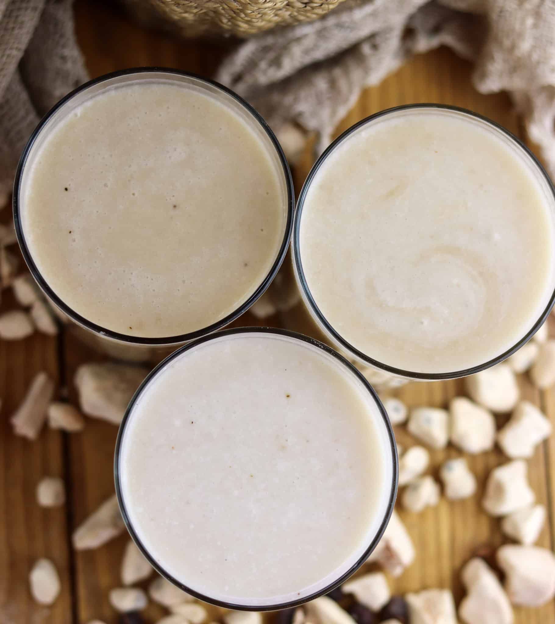 Glasses full of baobab juice with coconut and banana, waiting to be served on the table.