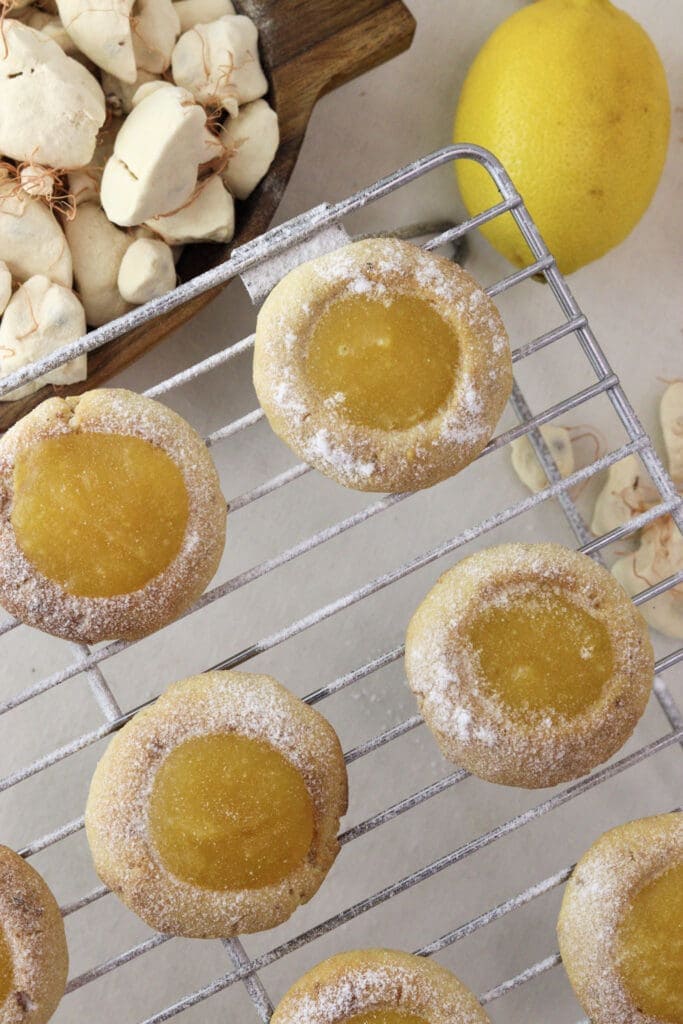 Lemon baobab cookies dusted with powdered sugar on a cooling rack
