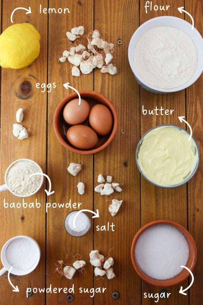 gathering ingredients for lemon baobab cookies: baobab powder, lemon, butter, flour, sugar, eggs and salt