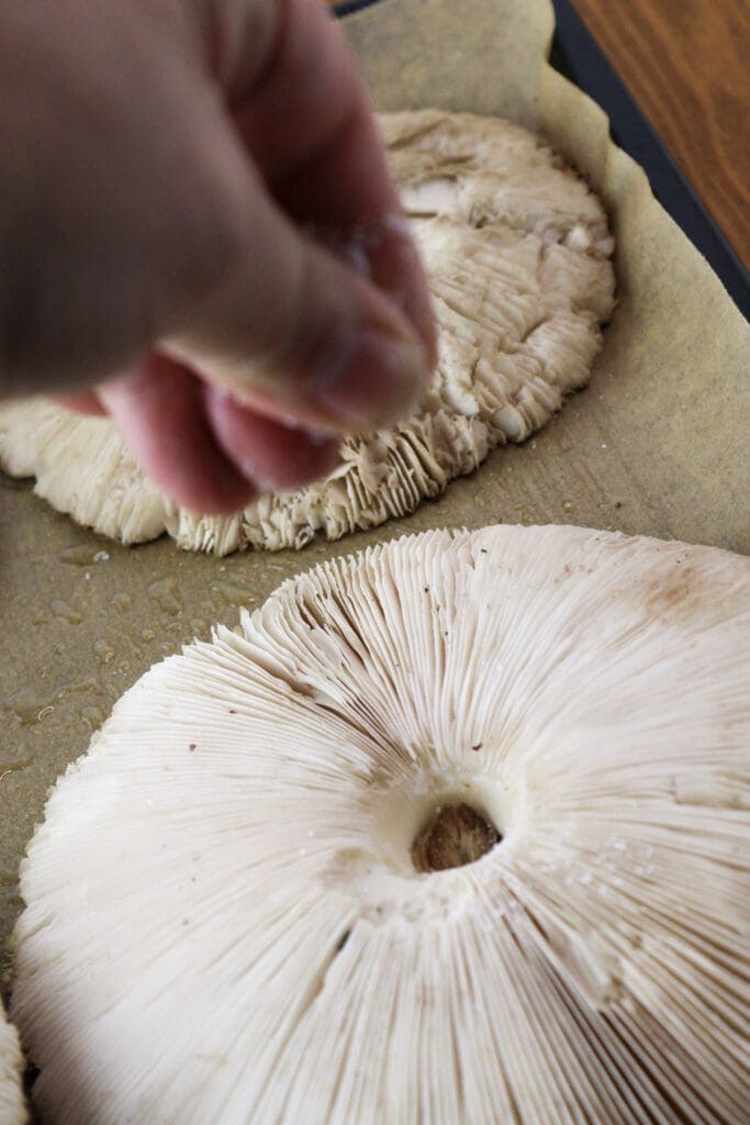 How to sprinkle the mushrooms with salt and black pepper before softening them in the oven.