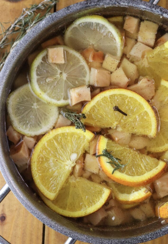Image of chicken of the woods cooking together with orange, lemon, rosemary and cloves in sweet sugar syrup