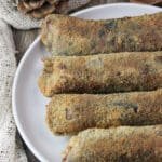 Four fried parasol mushroom rolls stuffed with mozzarella and smoked bacon served on a rustic plate