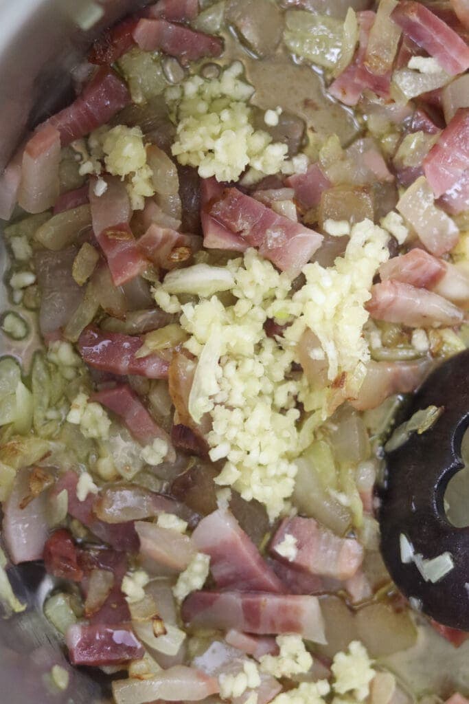 How to add crushed garlic to smoked bacon and onions right before adding potatoes, sauerkraut, beans and sausages
