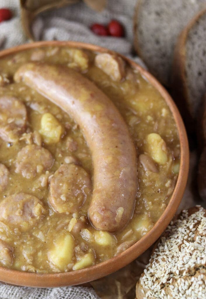 Carniolan sausage on top of homemade jota soup with homemade buckweat bread in the backgroud