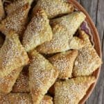 Crispy golden brown cracling cookies with sesame ona an old clay plate.