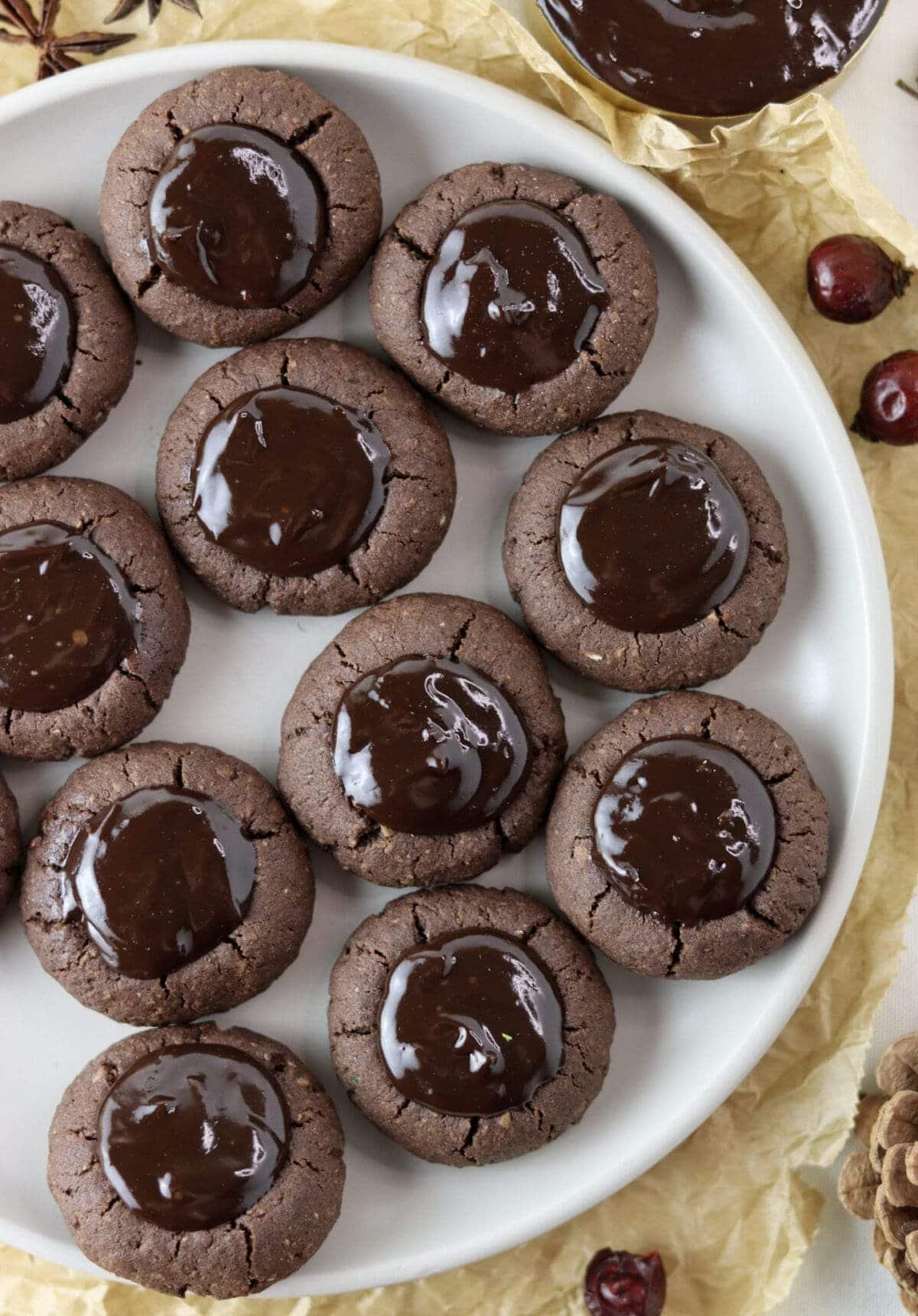 A full plate of buckwheat thumbprint cookies with chocolate filling with added orange zest.