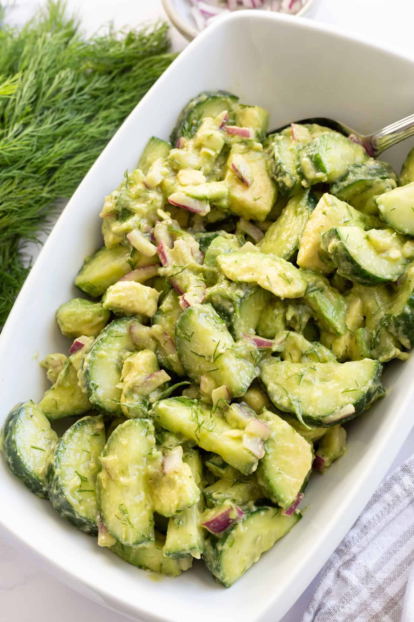 Crunchy and creamy cucumber avocado salad garnished with fresh dill.