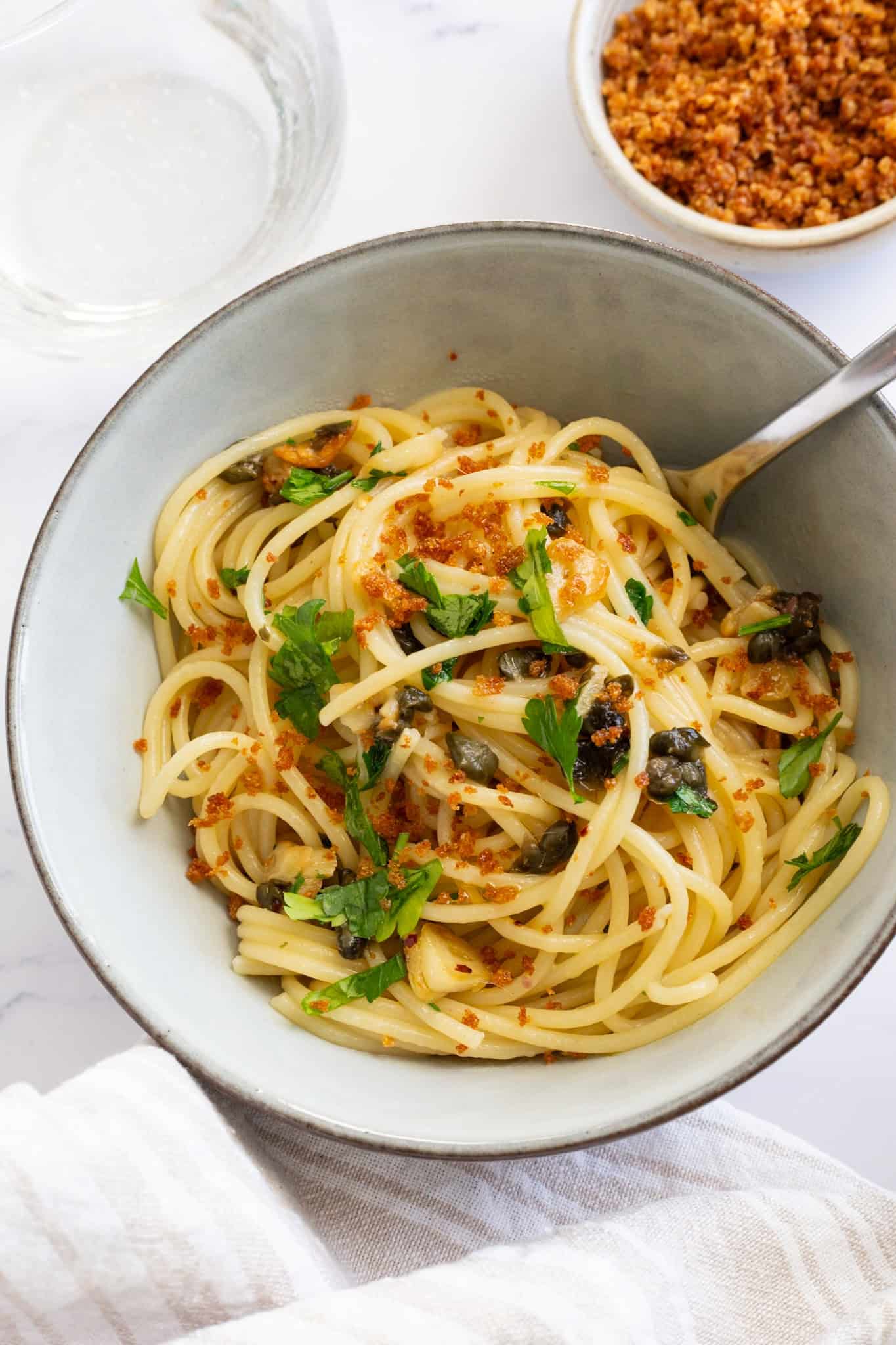 A bowl of caper and garlic pasta topped with crispy Panko breadcrumbs.