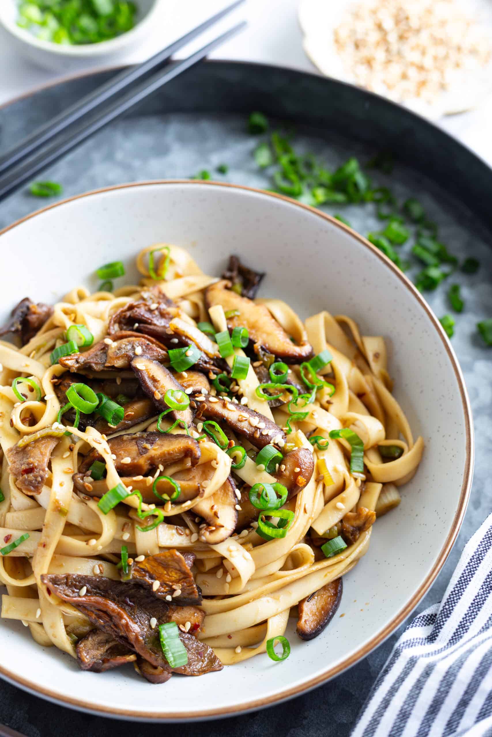 Shiitake mushroom noodles served in a bowl and garnished with scallions.