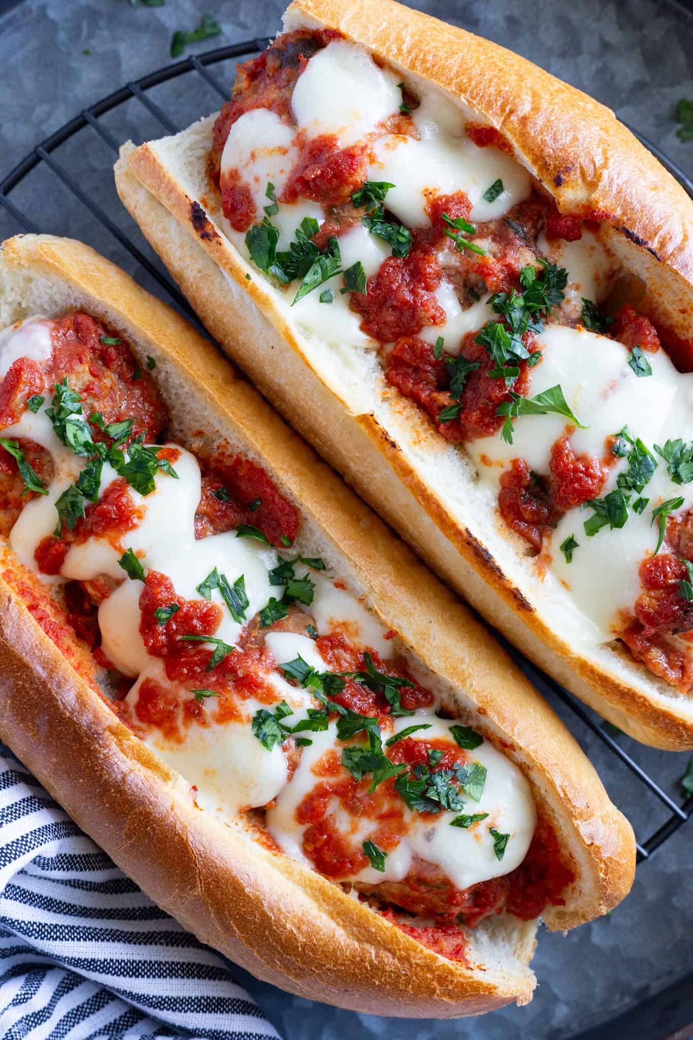 Two meatball Parm heros tucked between crispy hoagie-style rolls.
