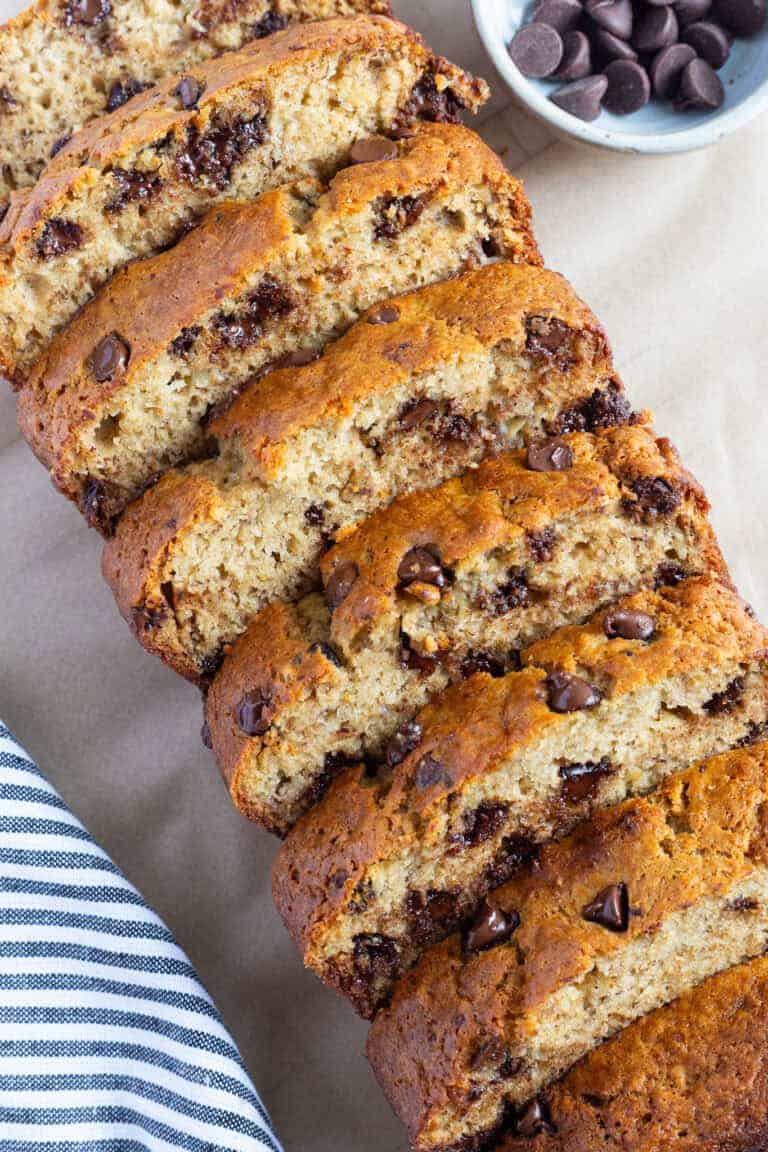 A sliced loaf of moist chocolate chip banana bread, made with 2 bananas.