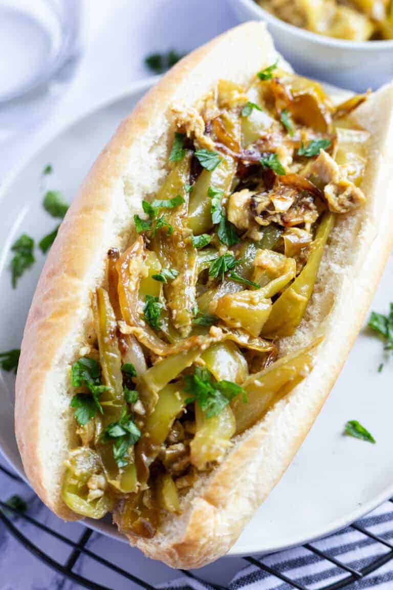 A hoagie roll filled with peppers and eggs.