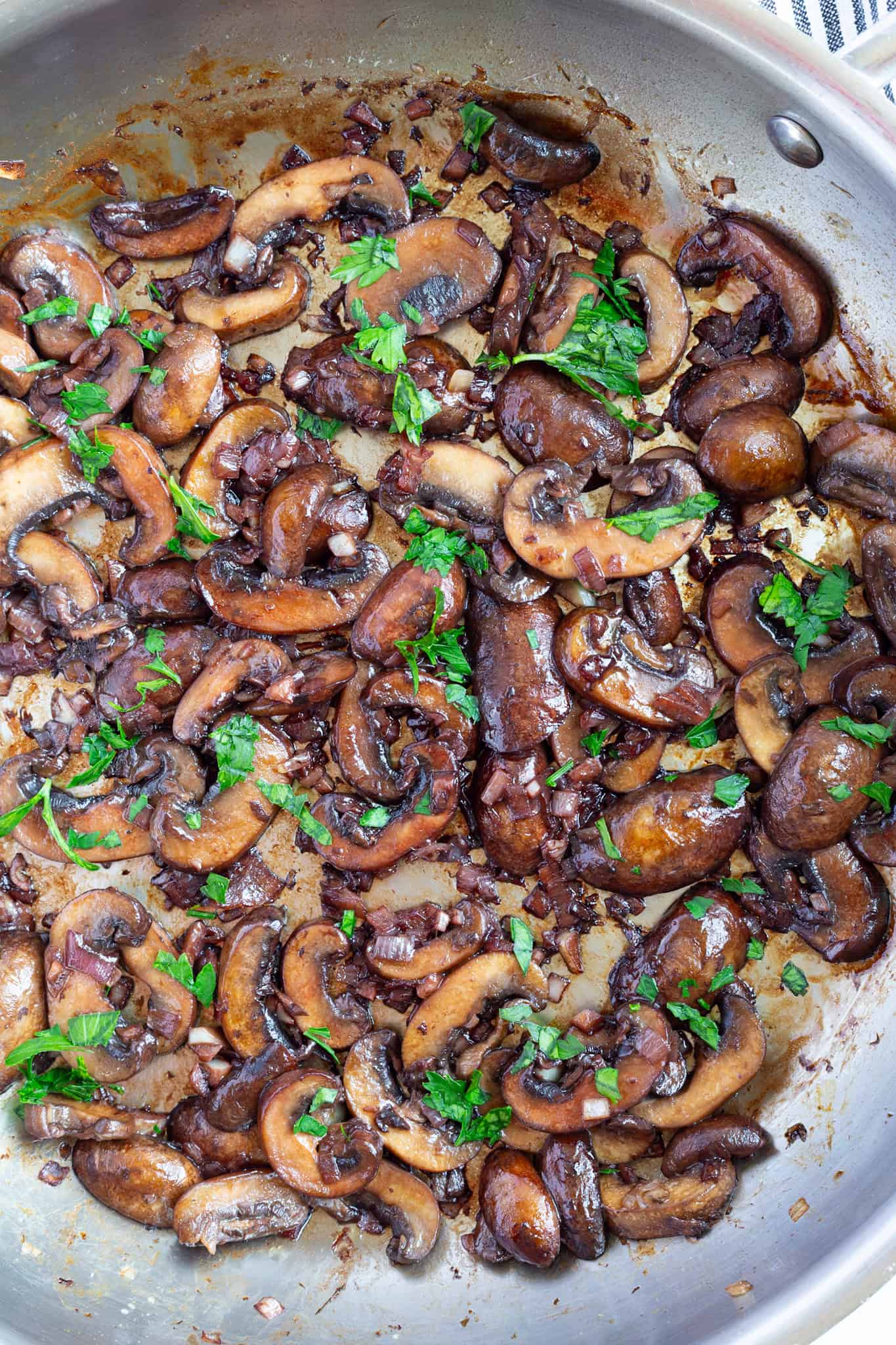 A pan of mushrooms sauteed with balsamic vinegar and red wine.