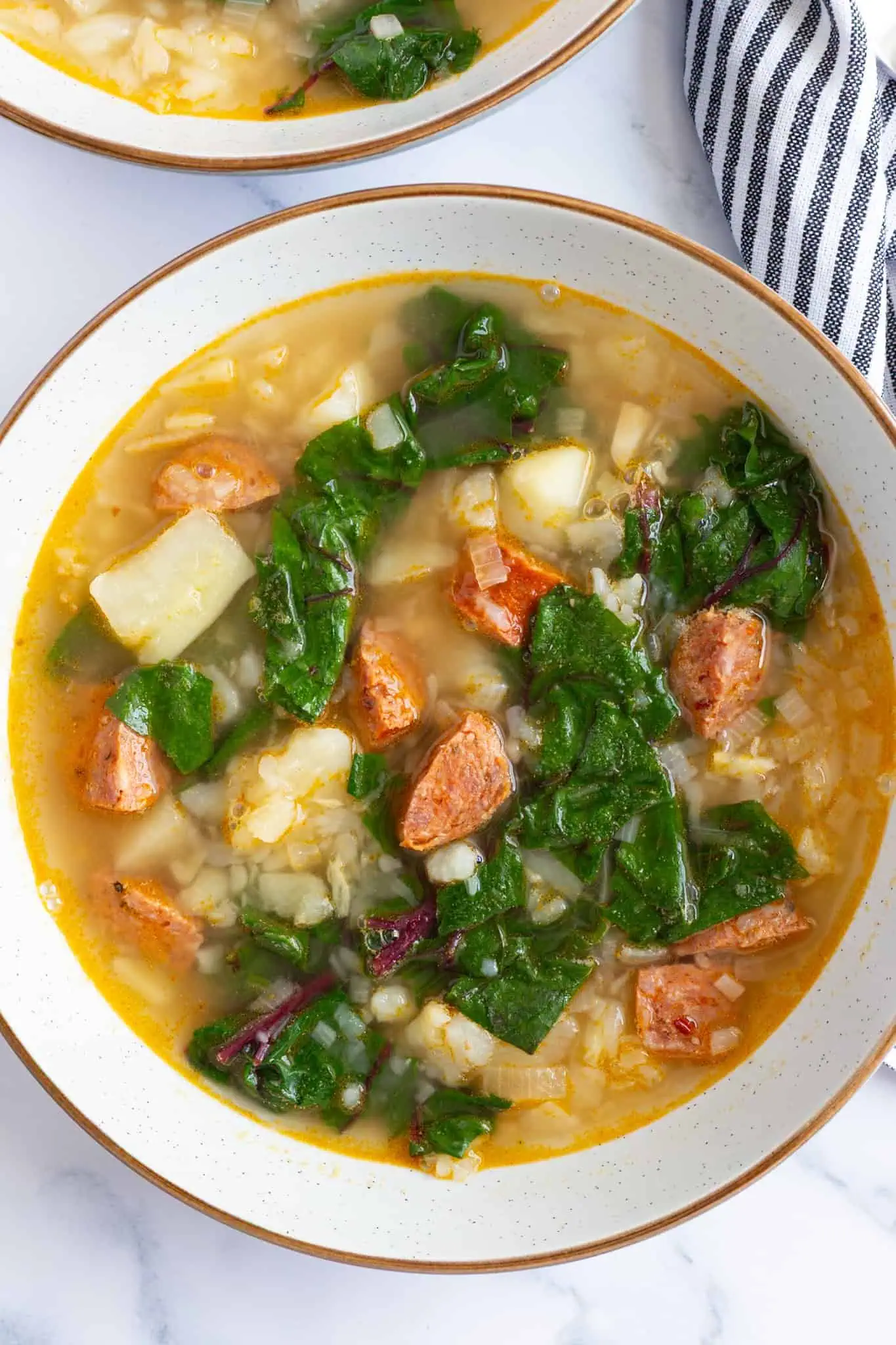 A bowl of soup with Swiss chard, potatoes, and chorizo.