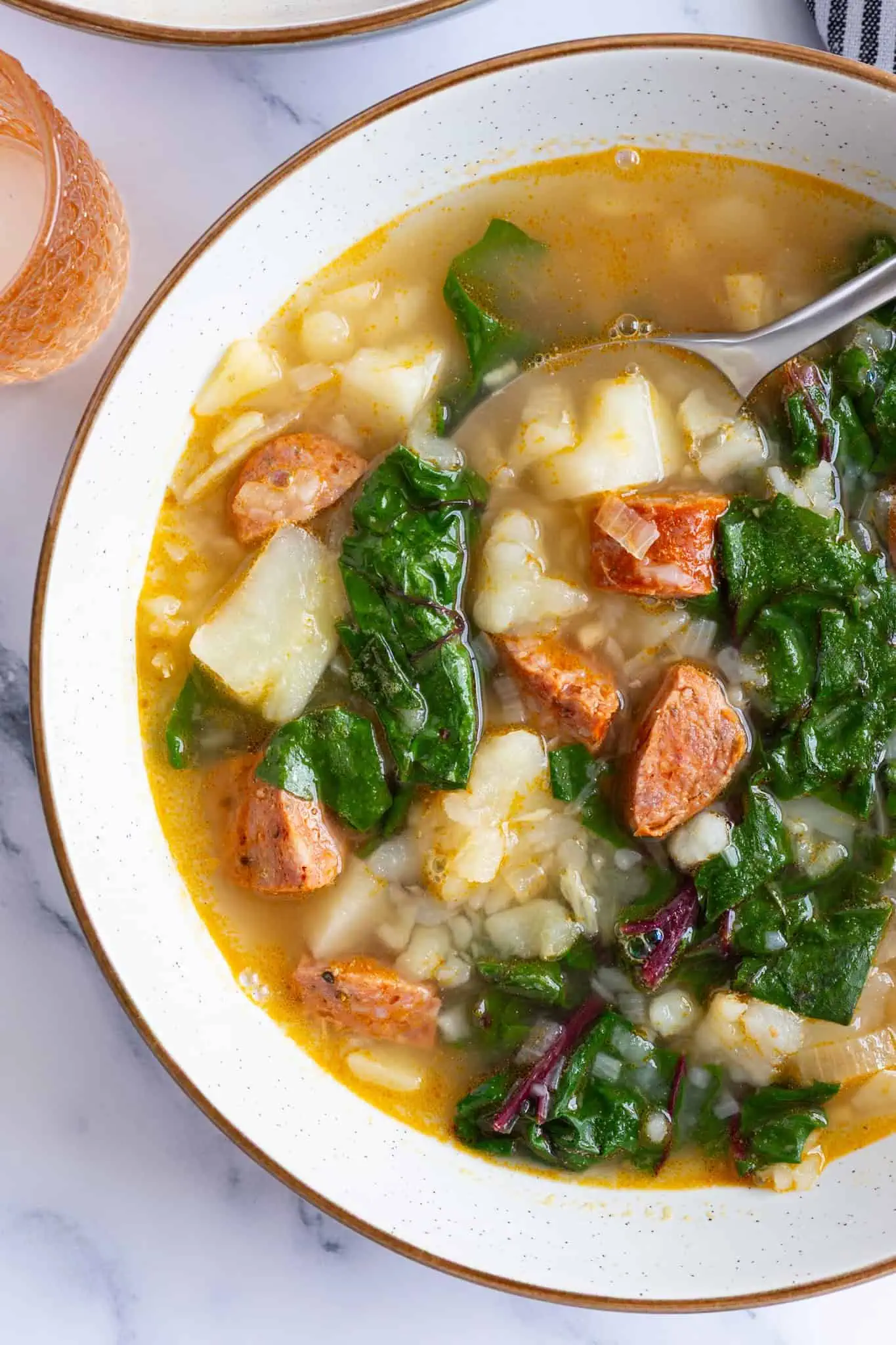 A bowl of cozy Swiss chard soup with chorizo.