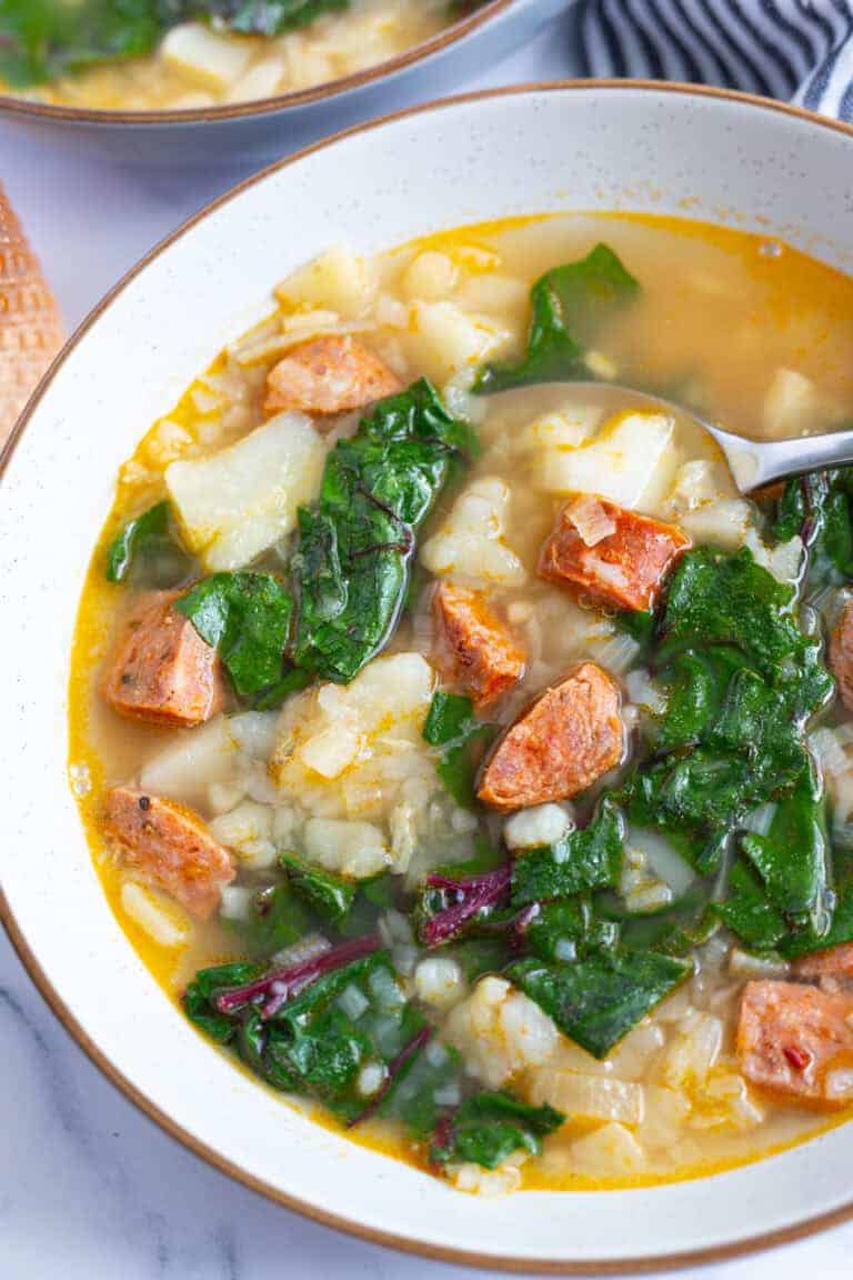 A bowl of chorizo potato soup with Swiss chard.