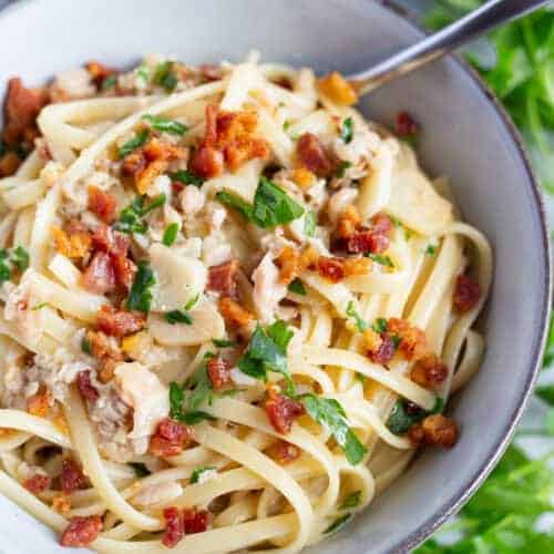 A bowl of crispy pancetta pasta with canned clams.