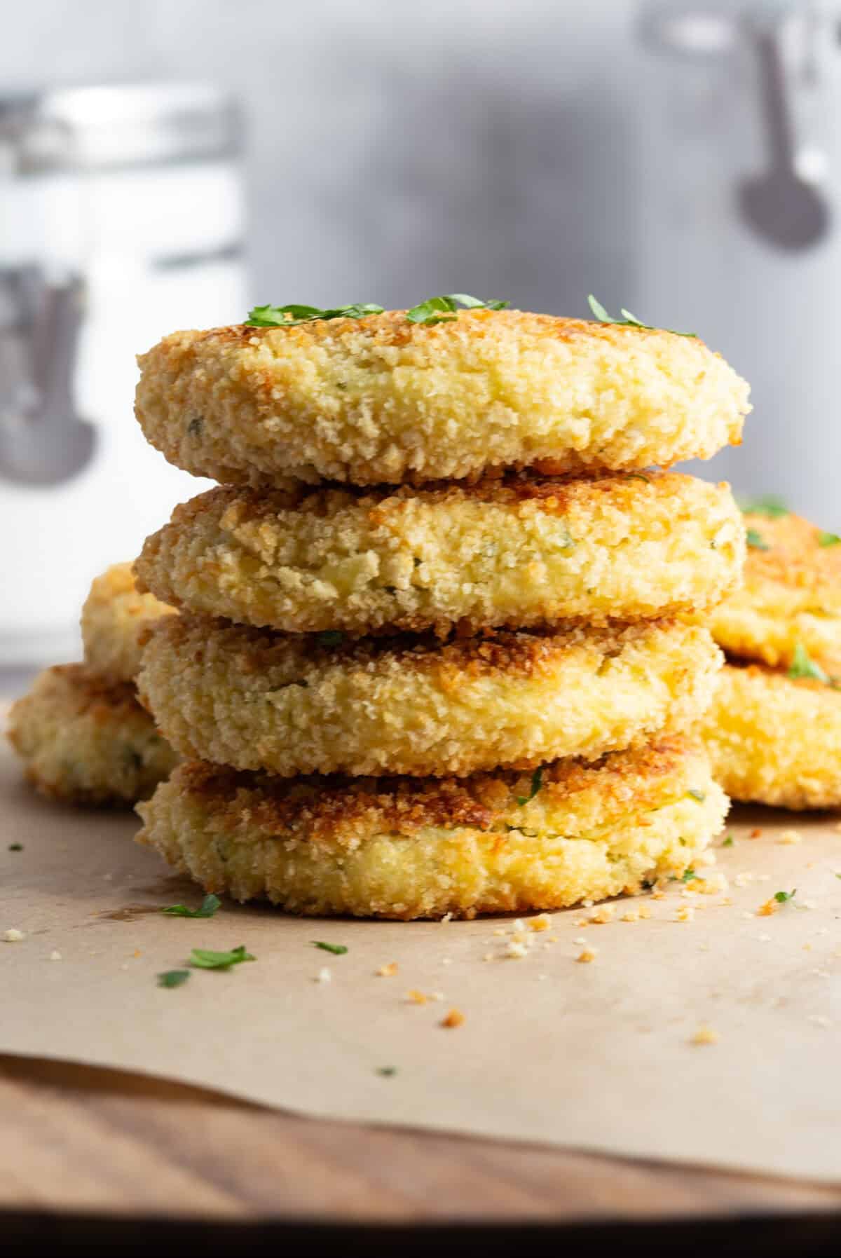 A stack of Italian potato croquettes garnished with fresh parsley leaves.