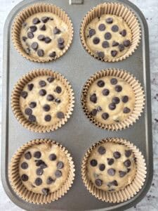 Filled muffin cups with chocolate chips added to tops.