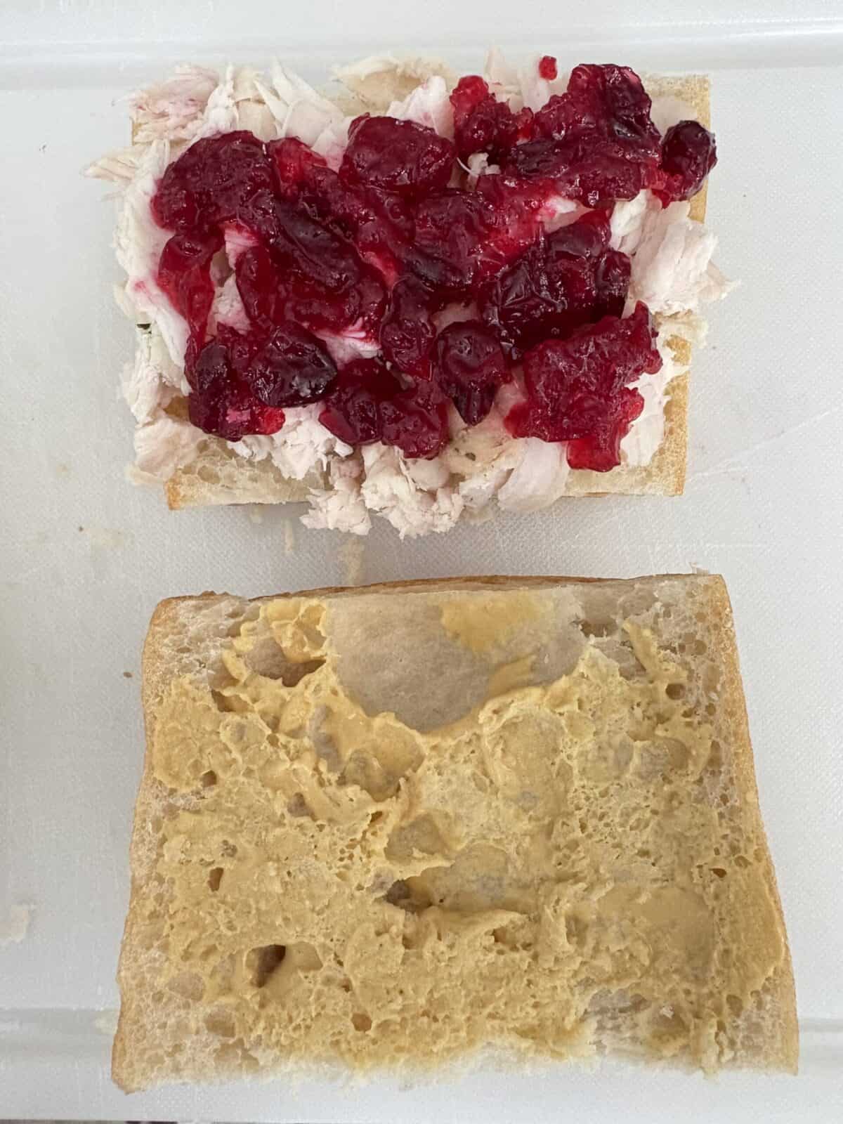 A slice of bread with turkey and cranberry sauce.
