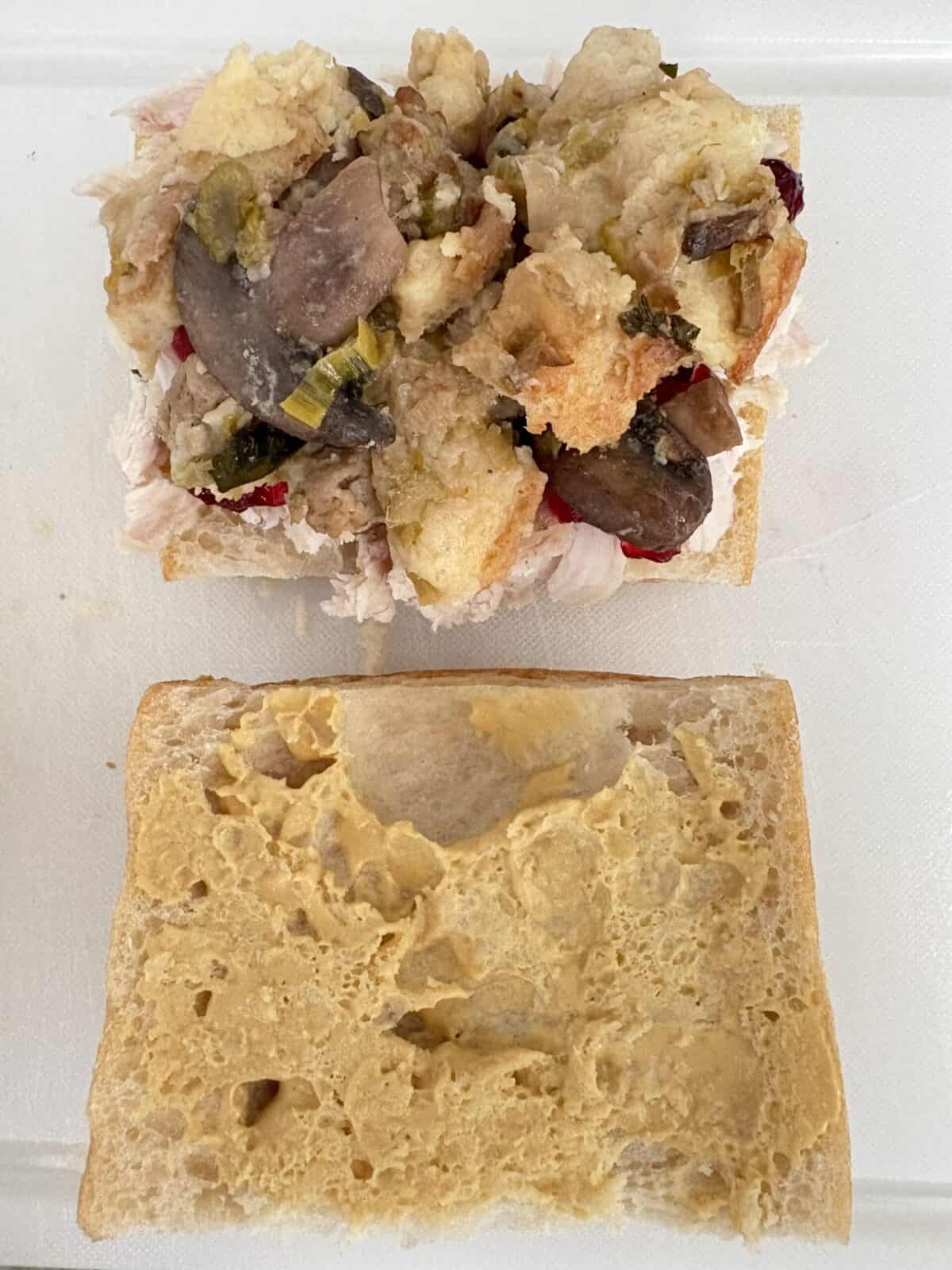 A slice of bread with turkey, cranberry sauce, and stuffing.