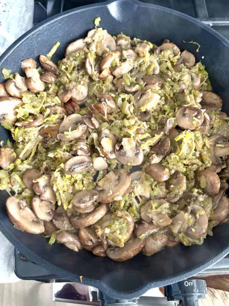 A pan of cooked mushrooms and leeks.