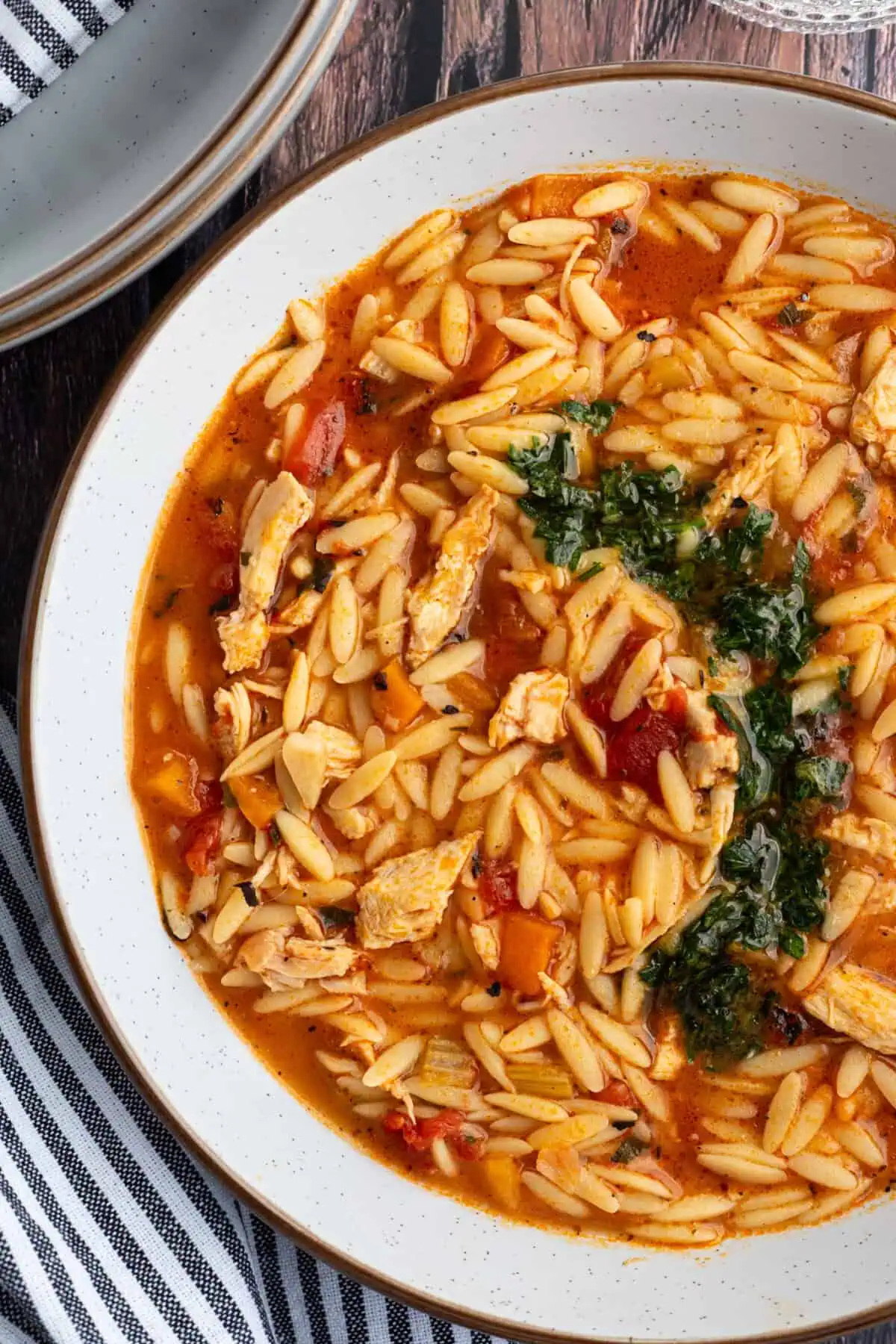 A bowl of turkey orzo soup garnished with gremolata.