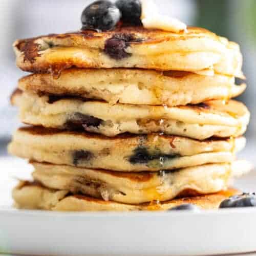 A stack of Betty Crocker pancakes with frozen blueberries.