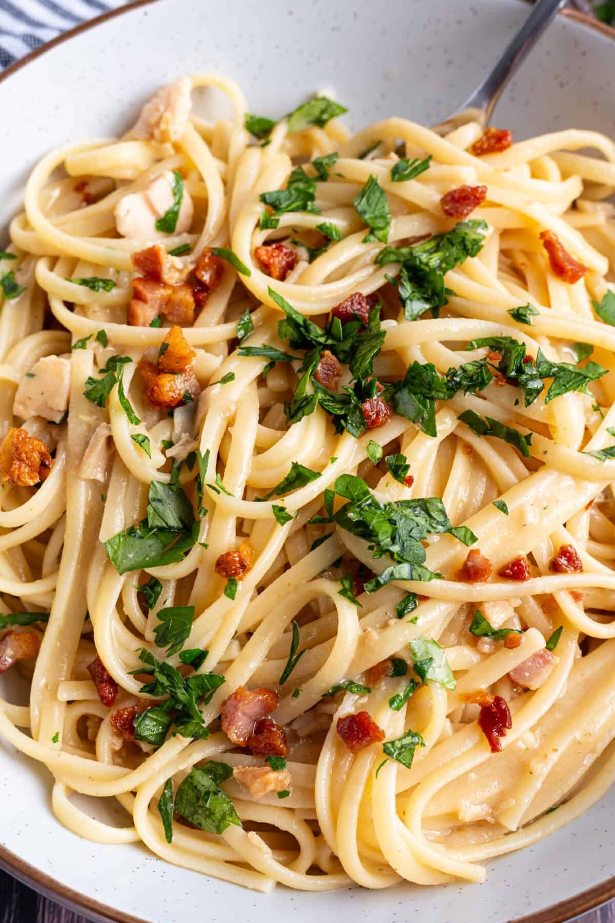 A plate of crispy pancetta pasta with canned clams.