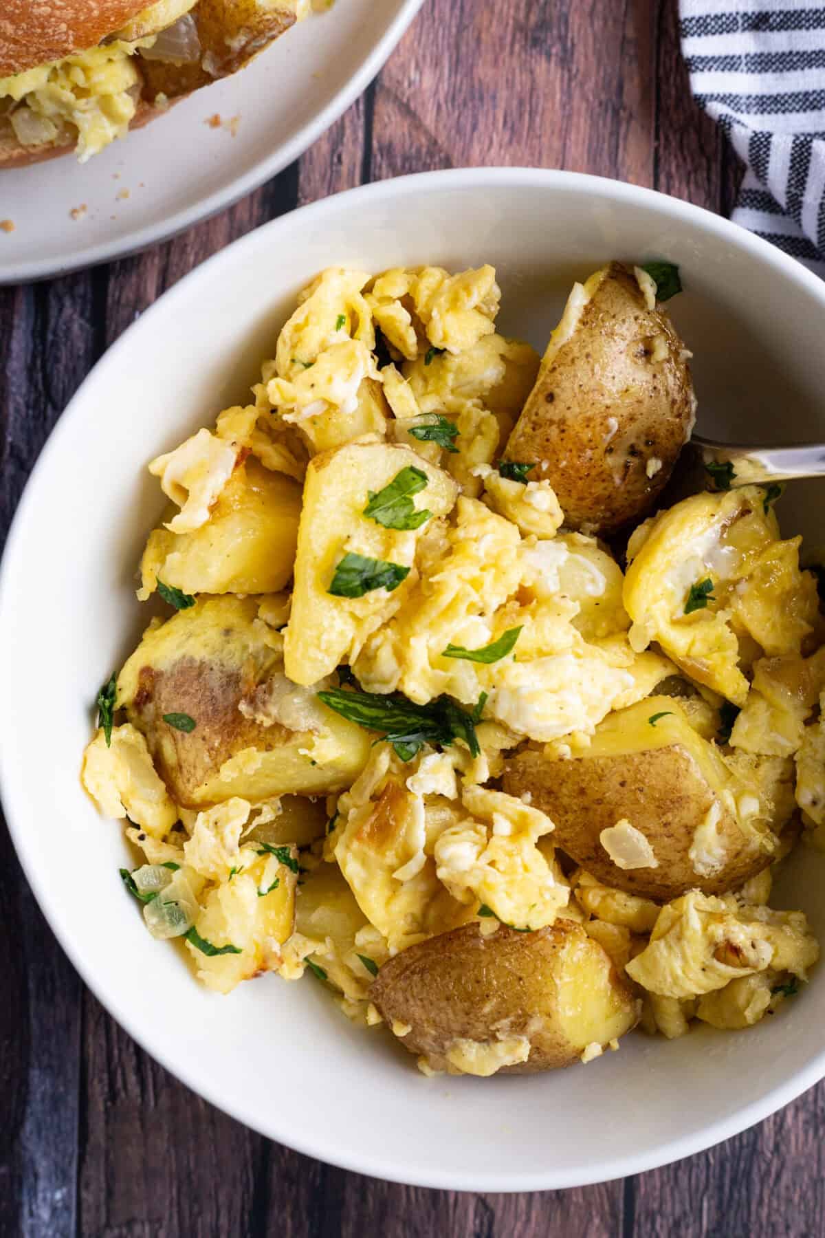 A bowl featuring a potatoes and eggs recipe.