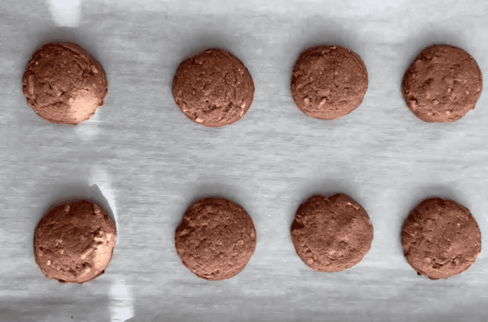 Baked almond cocoa powder cookies on a baking sheet.