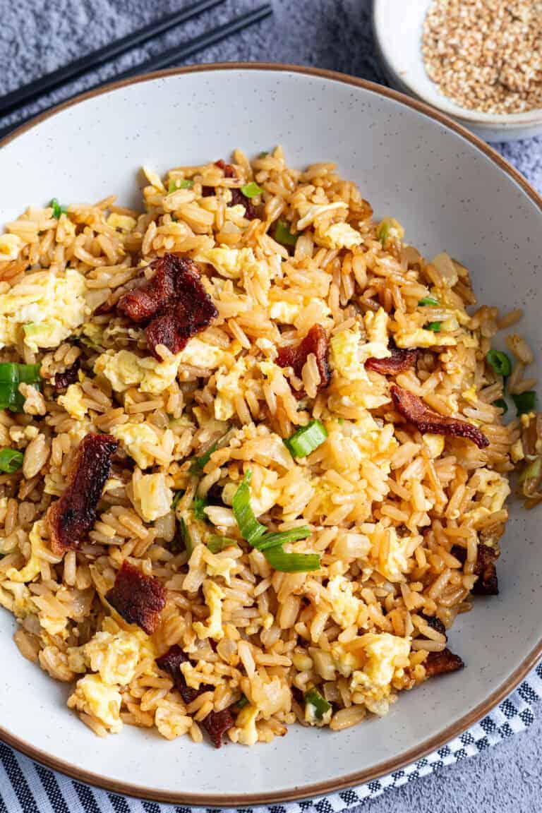 Bacon and egg fried rice garnished with scallions.