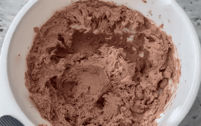 Almond cocoa powder cookie batter in a bowl.