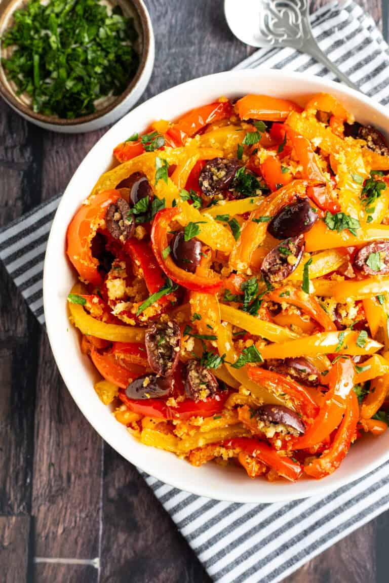A bowl of cooked sweet bell peppers and olives.
