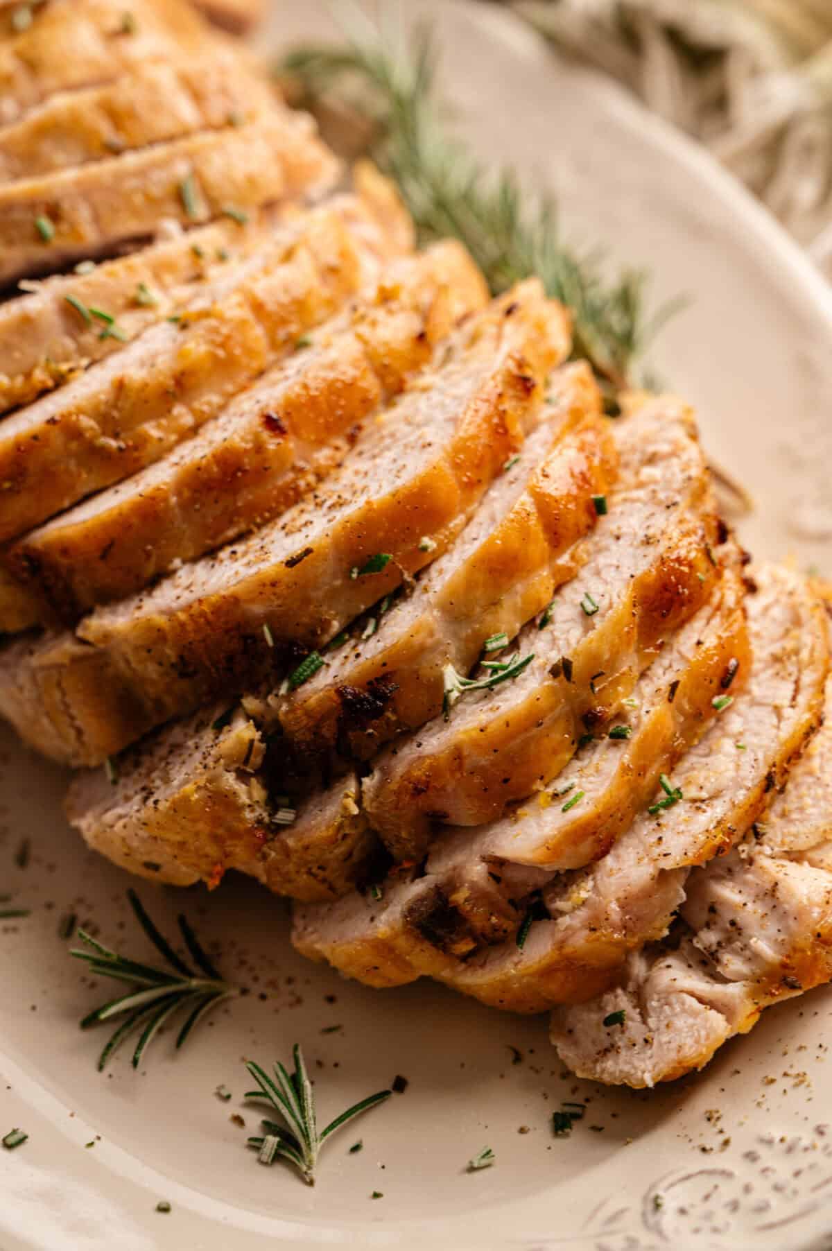 A platter of sliced, golden turkey breast.
