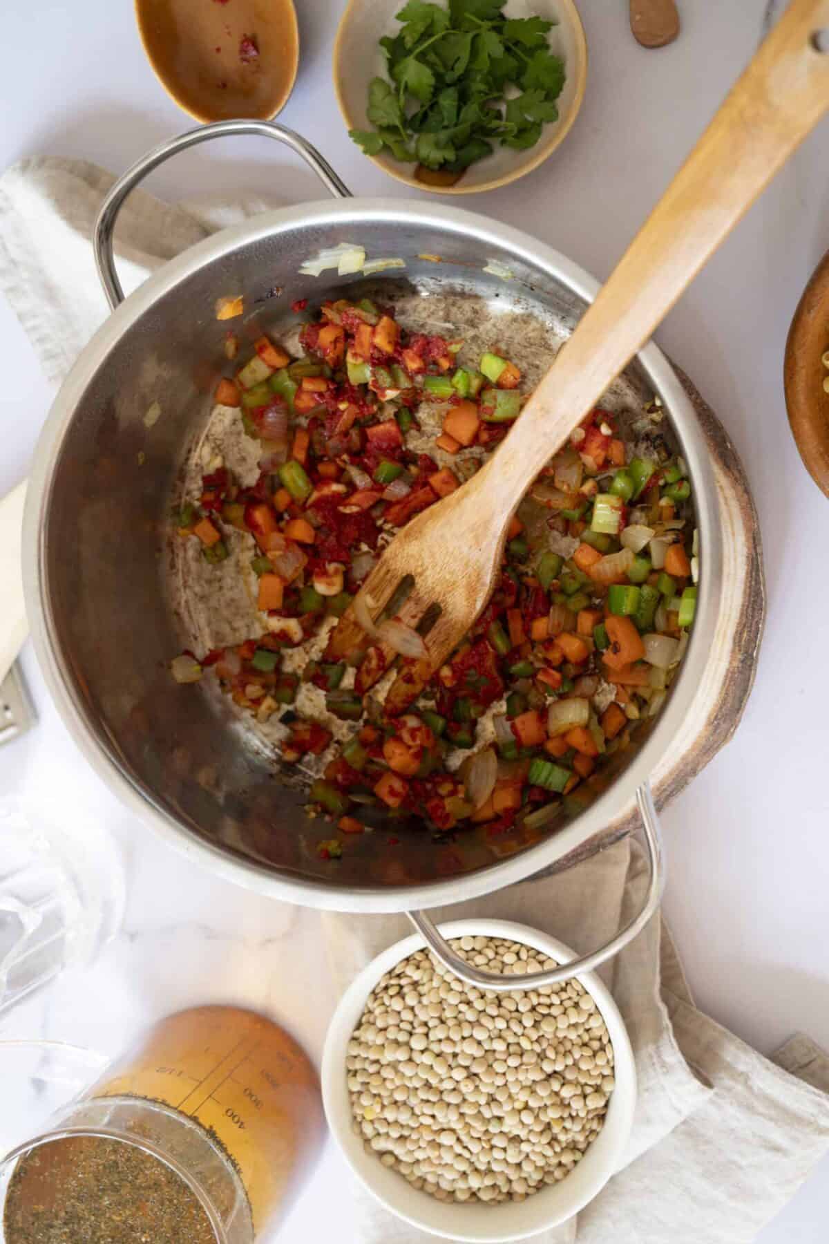 Tomato paste cooked down in a pot with vegetables.