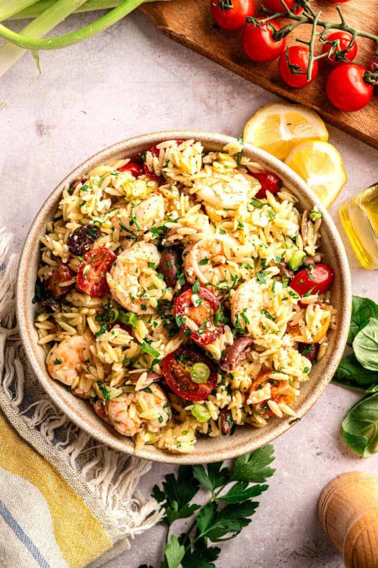 A big bowl of shrimp orzo salad with olives and feta.