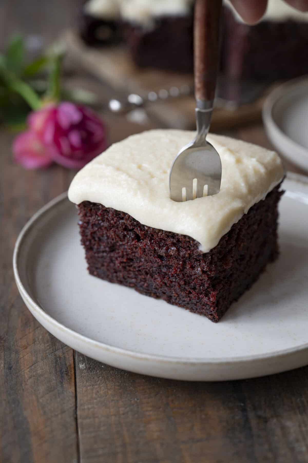 A fork inserted into a piece of chocolate cake.