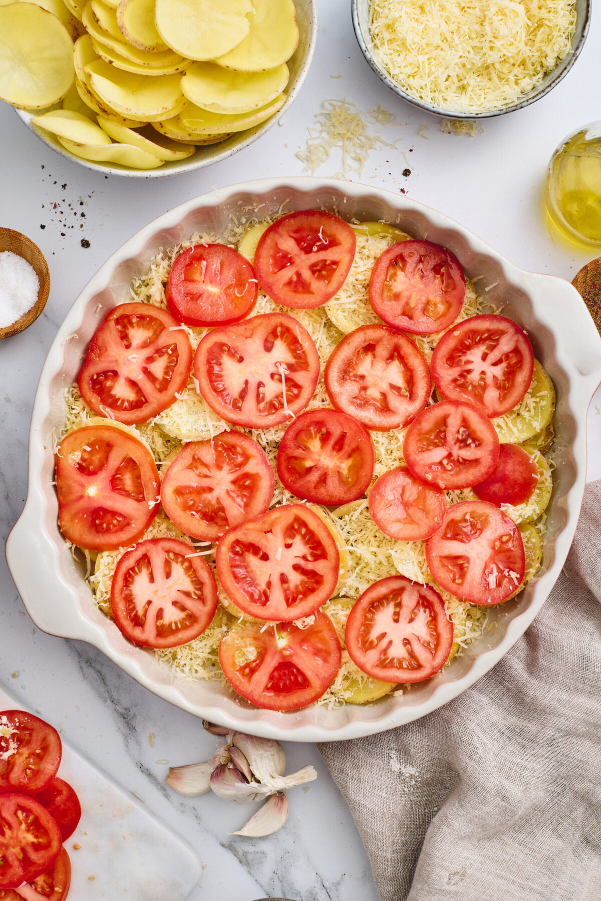 A dish of layered potatoes and tomatoes with cheese.