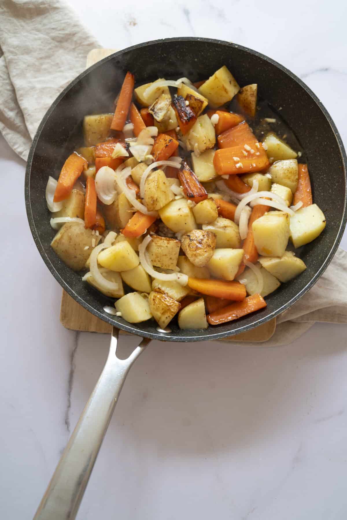 Potatoes and carrots simmering in wine.