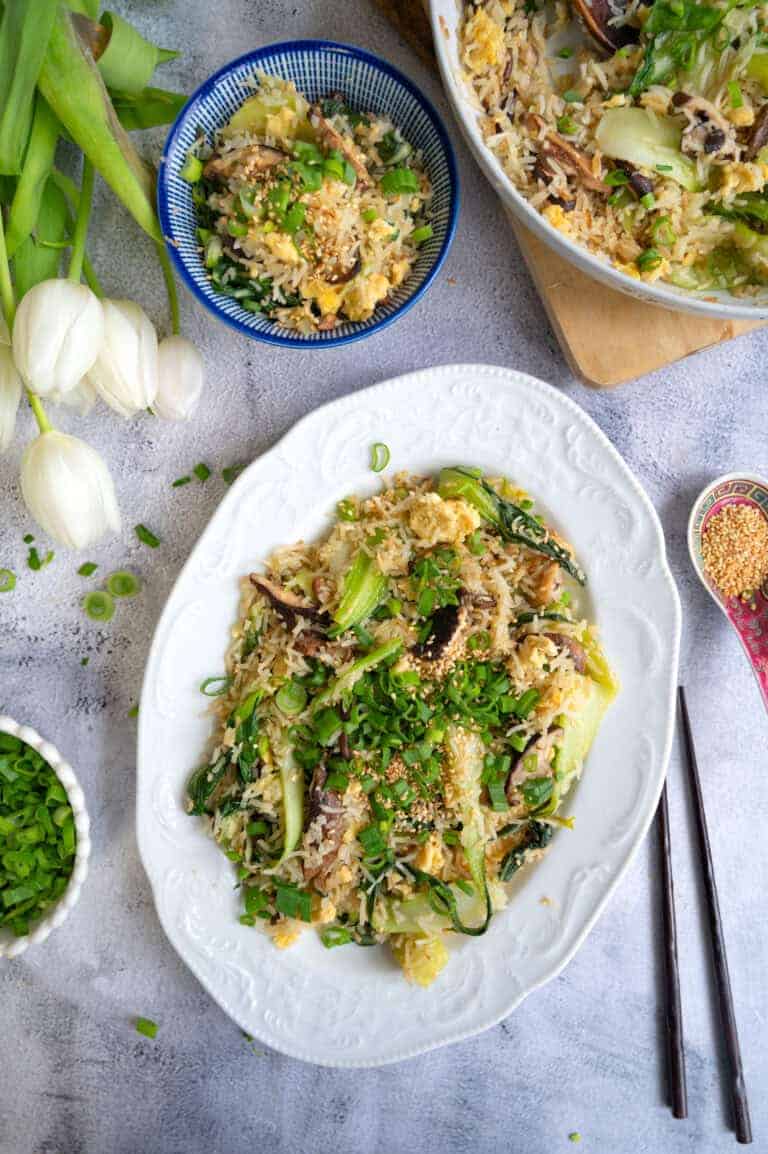 Bok choy fried rice garnished with scallions and toasted sesame seeds.