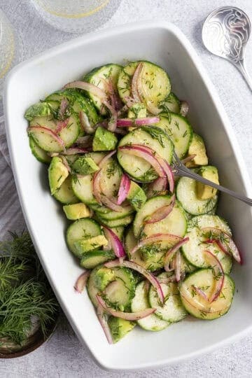 A cucumber salad dressed with dill, red onion, and avocado.