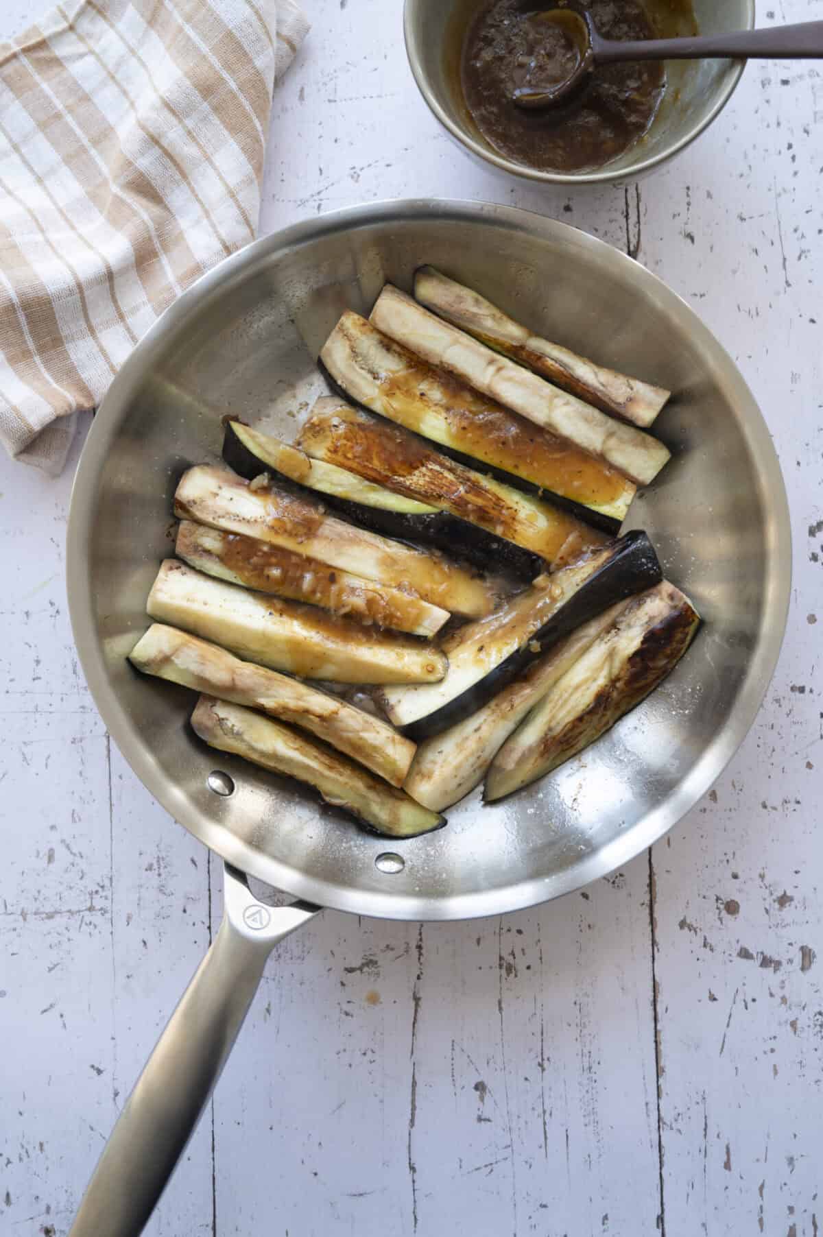 A pan of eggplant with some garlic sauce.