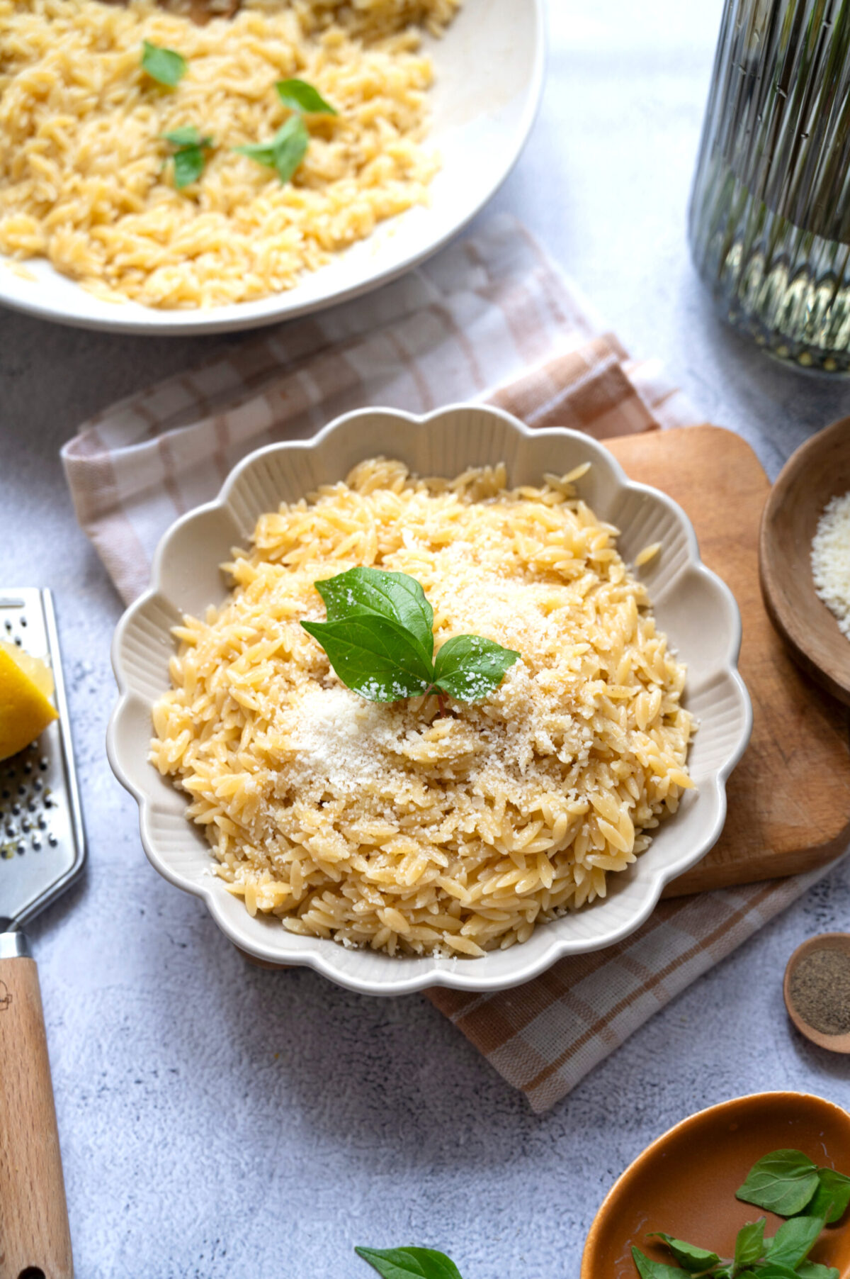 A bowl of lemon orzo with basil sprigs.